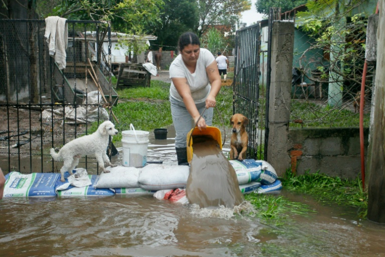 Une femme évacue de l'eau pendant une inondation à Agua Azul, dans la province de Tucuman, en Argentine, le 11 mars 2026 ( AFP / Walter Monteros )