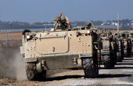 Un convoi de véhicules blindés de transport de troupes prend position près de la frontière entre Israël et la bande de Gaza
