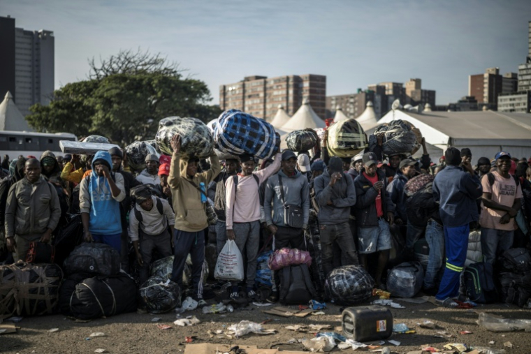 Des immigrés en situation irrégulière attendent à Durban, en Afrique du Sud, d'être transférés dans un centre de transit près de la frontière avec le Zimbabwe, le 29 juin. ( AFP / MARCO LONGARI )