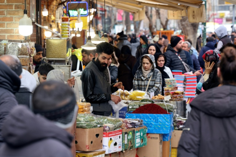 Des Iraniens font des commissions, au Grand Bazar de Téhéran, le 20 janvier 2026 ( AFP / ATTA KENARE )