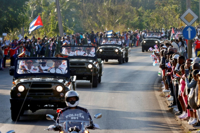 Des Cubains saluent le cortège funèbre transportant les restes des 32 soldats cubains morts lors de l'opération américaine ayant conduit à la capture du dirigeant vénézuélien Nicolás Maduro, à La Habane, le 15 janvier 2026 ( POOL / Ernesto Mastrascusa )