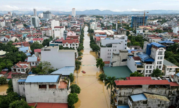 Vue aérienne de sauveteurs se déplaçant en bateau dans une rue inondée après les fortes pluies causées par le typhon Matmo dans la ville de Thai Nguyen, au Vietnam, le 8 octobre 2025 ( AFP / STR )