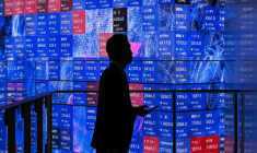 Une personne attend devant un panneau électronique à la Bourse de Tokyo, le 5 novembre 2025 ( AFP / GREG BAKER )