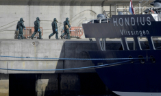 Des personnes en combinaisons de protection se dirigent vers le bateau de croisière MV Hondius, touché par l'hantavirus, dans le port de Granadilla de Abona, sur l'île de Tenerife, dans l'archipel espagnol des Canaries, le 11 mai 2026 ( AFP / JORGE GUERRERO )