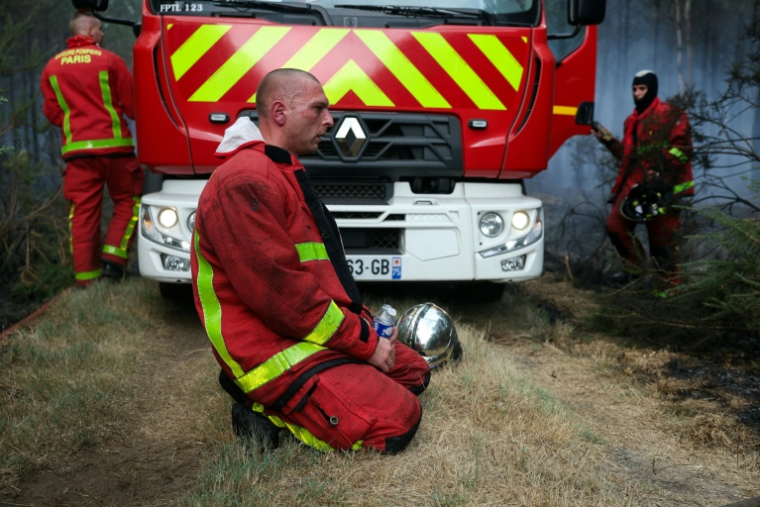 Des sapeurs-pompiers de la Brigade de sapeurs-pompiers de Paris se reposent à Marcheprime, à l’ouest de Bordeaux, le 26 juillet 2026, alors qu’un incendie de forêt ravage la forêt au nord du bassin d’Arcachon (Gironde) depuis le 22 juillet ( AFP / ALAIN JOCARD )