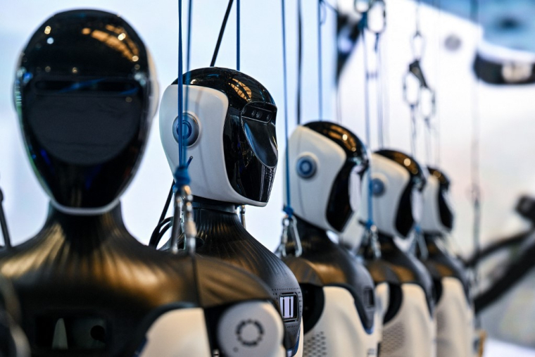 Des robots humanoïdes de OpenMind Robotics, à Shanghaï, le 18 juillet 2026 ( AFP / HECTOR RETAMAL )