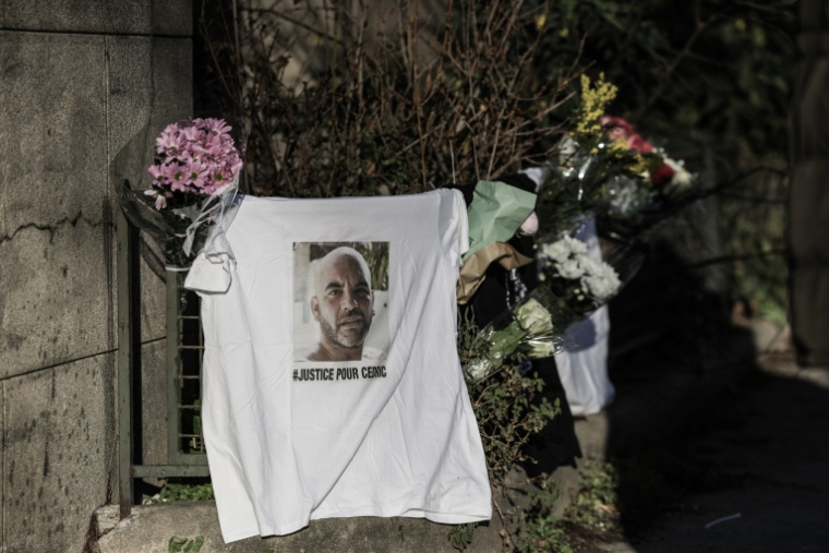 Un portrait de Cédric Chouviat et des fleurs déposés lors d'un hommage à Paris le 3 janvier 2025 ( AFP / Thibaud MORITZ )