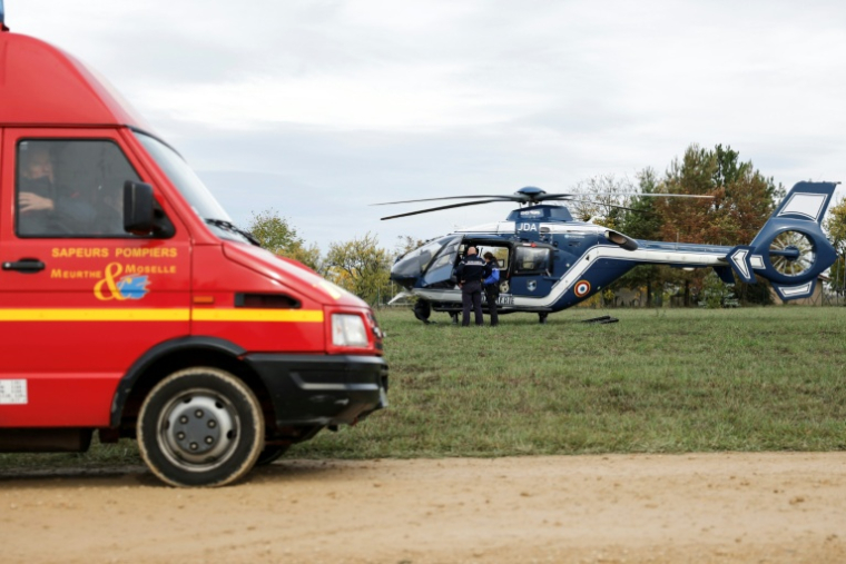 Des gendarmes et des sapeurs-pompiers lors d'une opération de secours visant à retrouver un avion de chasse Mirage 2000D qui s'est écrasé lors d'un vol d'entraînement, à Rogéville, le 21 octobre 2026 en Meurthe-et-Moselle ( AFP / ROMEO BOETZLE )