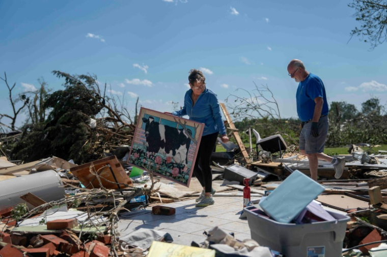 Un couple tente de récupérer quelques objets dans les ruines de leur maison après une tornade à London, dans le Kentucky, le 17 mai 2025 ( AFP / Allison Joyce )