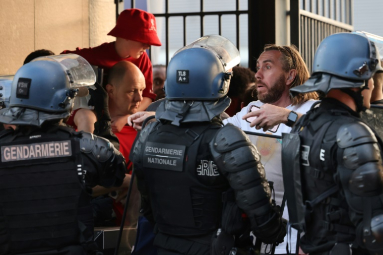 Des gendarmes font face à des supporters le 28 mai 2022 au Stade de France, à Saint-Denis, avant la finale de la Ligue des champions opposant Liverpool au Real Madrid ( AFP / Thomas COEX )