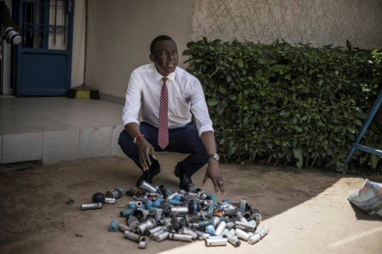 (Photo archives) Succès Masra, président du parti d'opposition tchadien "Les Transformateurs", devant des grenades lacrymogènes, grenades assourdissantes et autres projectiles qu'il accuse la police d'avoir utilisés contre la foule, à N'Djamena le 8 avril 2021 ( AFP / MARCO LONGARI )