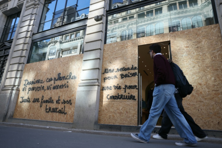 Un magasin protégé par des plaques de bois à Paris le 30 octobre 2026 ( AFP / Thomas SAMSON )