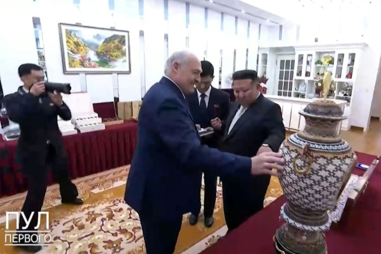 Image tirée d'une vidéo publiée sur le compte Telegram pul_1 et reçue via l'AFPTV, le 26 mars 2026, montrant le président biélorusse Alexandre Loukachenko (2e g) touchant un vase qui lui a été offert par le dirigeant nord-coréen Kim Jong-un (d) à Pyongyang ( TELEGRAM/@pul_1 / - )