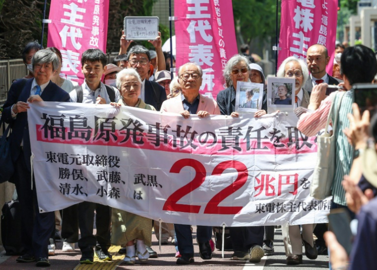 Des plaignants déploient une banderole demandant aux anciens responsables de la compagnie Tepco, opérant la centrale nucléaire de Fukushima, de "prendre la responsabilité de l'accident nucléaire de Fukushima - 22 000 milliards de yens", à Tokyo le 6 juin 2025 ( JIJI Press / STR )