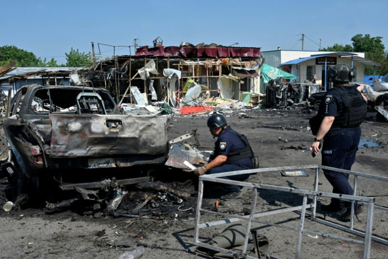 Des policiers sur les lieux d'une frappe russe à Petcheniguy, le 18 août 2026 dans la région de Kharkiv, en Ukraine ( AFP / SERGEY BOBOK )
