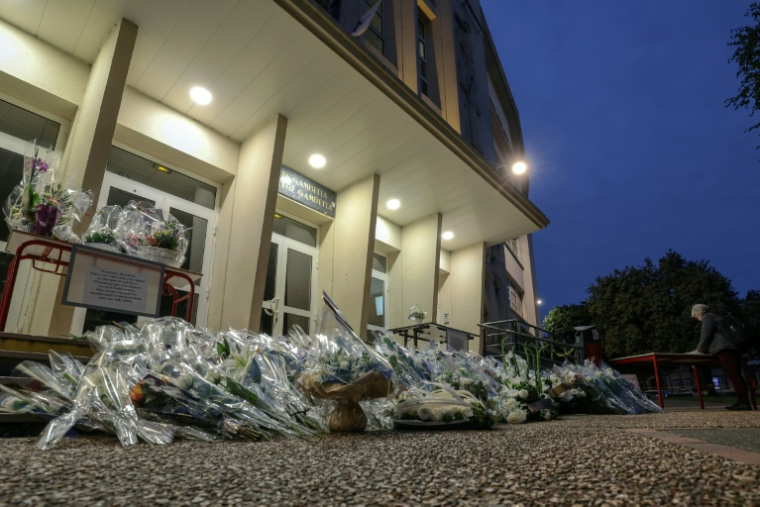 Des fleurs déposées devant le lycée Gambetta d'Arras en hommage au professeur de français Dominique Bernard, tué lors d'une attaque au couteau, le 13 octobre 2026 dans le Pas-de-Calais ( AFP / Denis Charlet )