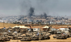 Des tanks et des bulldozers israéliens déployés à la lisière de la bande de Gaza, d'où s'élève de la fumée de bâtiments détruits par des frappes israéliennes, le 17 mai 2025 ( AFP / Jack GUEZ )
