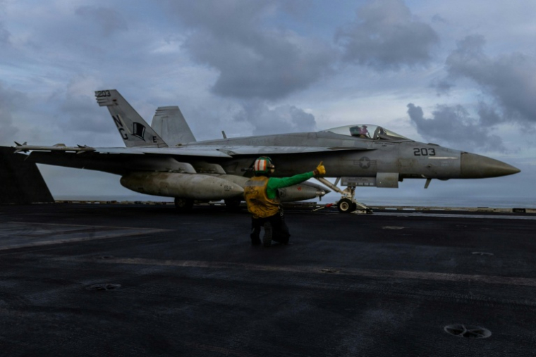 Photo diffusée par le service des affaires publiques du Commandement central américain, le 24 mars 2026, montrant un F/A-18E Super Hornet sur le pont d'envol du porte-avions USS Abraham Lincoln en soutien à l'opération Epic Fury, le 22 mars 2026 ( US Airforce / - )