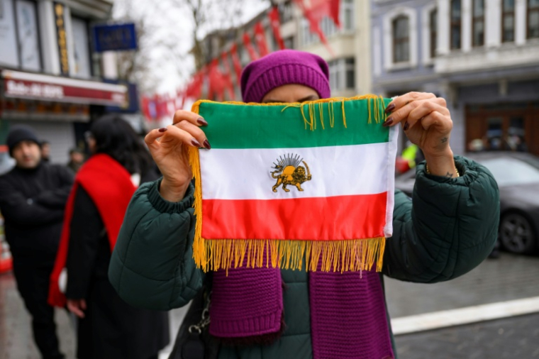 Une manifestante brandit le drapeau de soutien au fils du Shah, Reza Pahlavi, lors d'un rassemblement interdit près du consulat d'Iran à Istanbul, le 11 janvier 2026  ( AFP / Yasin AKGUL )