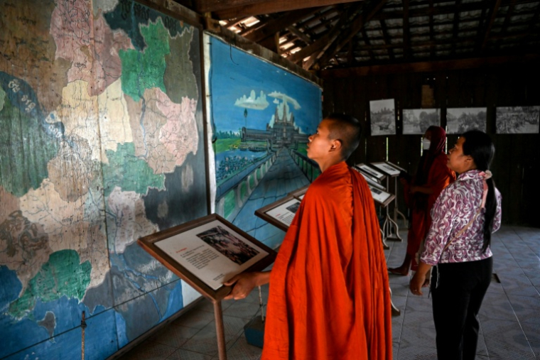Deux personnes dans la maison de l'ancien commandant Khmer Rouge Ta Mok dans le quartier d'Anlong Veng, dans la province d'Oddar Meanchey, au Cambodge, le 22 mars 2025 ( AFP / TANG CHHIN Sothy )
