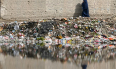 Une femme marche à côté de déchets, notamment plastique, le 6 mai 2018 à Kaboul ( AFP / DOMINIQUE FAGET )