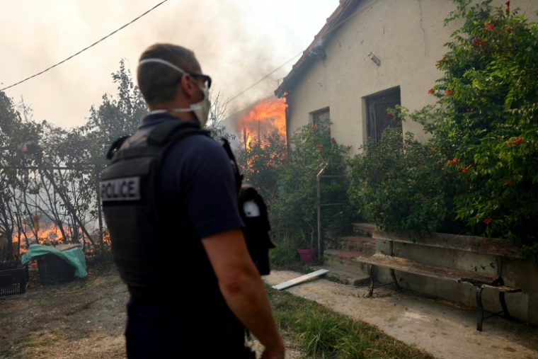 Un policier près d'un incendie de forêt se propageant dans le quartier de l'Estaque à Marseille, le 8 juillet 2025 dans les Bouches-du-Rhône ( AFP / Clement MAHOUDEAU )
