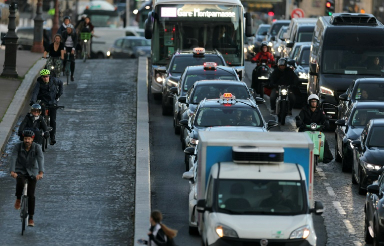 Des cyclistes et automobilistes, à l'heure de pointe à Paris, le 8 octobre 2024 ( AFP / Thomas SAMSON )