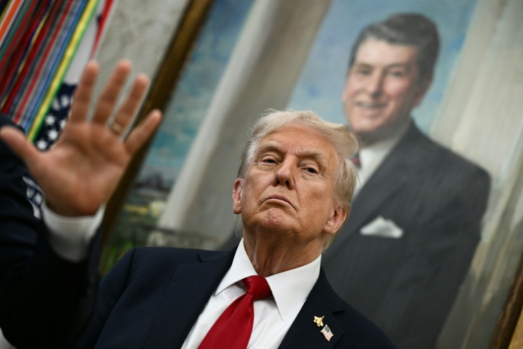 Le président américain Donald Trump devant un portrait de l'ex-président républicain Ronald Reagan, dans le Bureau ovale de la Maison Blanche, le 30 septembre 2025 ( AFP / Brendan SMIALOWSKI )
