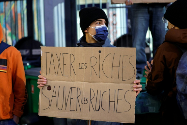 Un étudiant tient une pancarte tout en bloquant l'entrée de l'école Maurice-Ravel à Paris, le 18 septembre 2025 ( AFP / GEOFFROY VAN DER HASSELT )