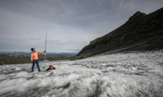 Le glaciologue Matthias Huss brandit une perche de mesure de quatre mètres de long, équivalant à la hauteur de la couche de glace ayant fondu en un an, le 24 septembre 2024 sur le glacier du Scex Rouge, en Suisse ( AFP / Fabrice COFFRINI )