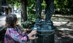 Une femme remplit un gobelet d'eau à une fontaine publique du quartier Montparnasse, le 25 mai 2026 alors que Météo-France a placé la capitale en alerte jaune face à une vague de chaleur exceptionnellement précoce ( AFP / STEPHANE DE SAKUTIN )