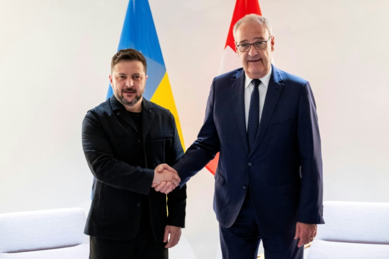 Le président suisse Guy Parmelin (d.) serre la main du président ukrainien Volodymyr Zelensky avant une rencontre bilatérale en marge du sommet du G7, à l'aéroport de Genève, le 15 juin 2026 ( POOL / MARTIAL TREZZINI )