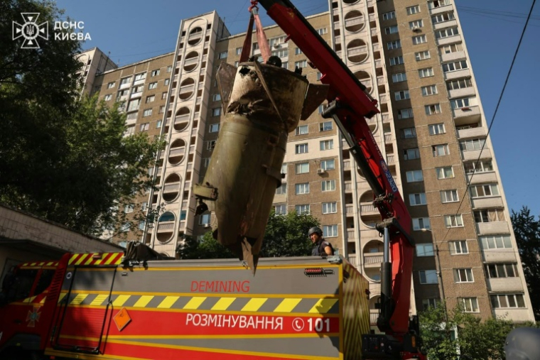 Photo prise et diffusée par le Service d'État pour les situations d'urgence , le 28 juin 2026, de démineurs retirant un fragment de missile russe, après une attaque aérienne à proximité d'immeubles résidentiels à Kiev, en Ukraine ( Service d'État pour les situations d'urgence de l'Ukraine / - )