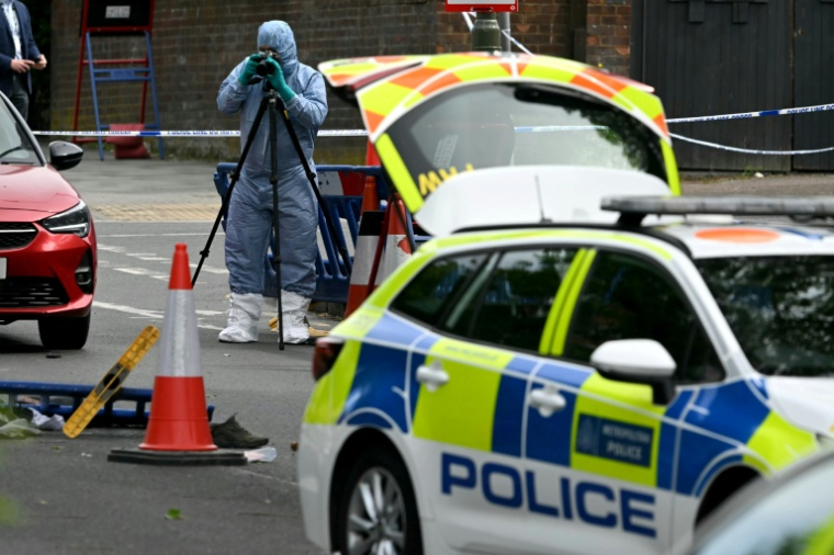 Un membre de la police scientifique photographie des indices sur les lieux d'un crime sur Golders Green Road, dans le quartier de Golders Green, au nord de Londres, après que deux personnes ont été poignardées et qu'un suspect a été arrêté ( AFP / JUSTIN TALLIS )