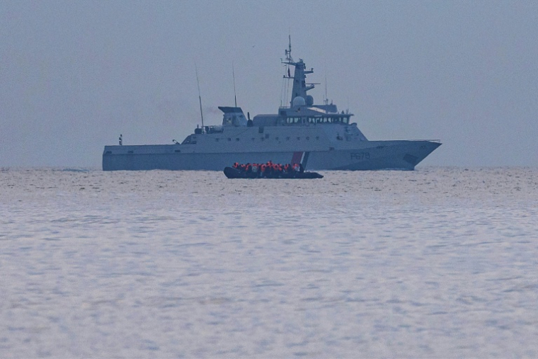 Un taxi-boat, transportant des migrants qui veulent traverser la Manche, passe devant un navire militaire français au large de la plage de Gravelines, dans le nord de la France, le 12 août 2025 ( AFP / Sameer Al-DOUMY )