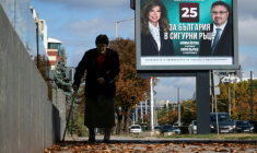 Une personne marche devant une affiche électorale de la présidente sortante de Bulgarie, Iliana Iotova, et de son vice-président candidat Kiril Valchev, à Sofia, le 23 octobre 2026 ( AFP / Nikolay DOYCHINOV )