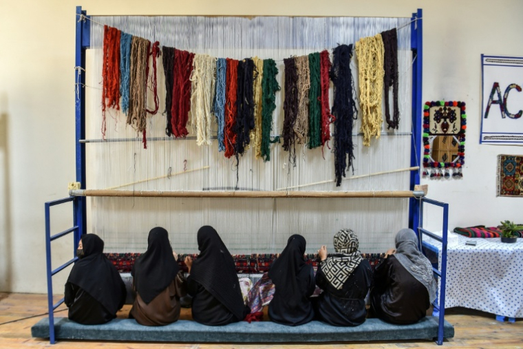 Des femmes travaillent dans une fabrique de tapis du district de Nahr-e-Shahi, dans la province de Balkh, le 6 juillet 2026 en Afghanistan ( AFP / Atif ARYAN )