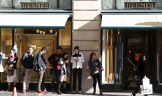 Des clients font la queue en attendant l'ouverture de la boutique principale du groupe de luxe français Hermès à Paris