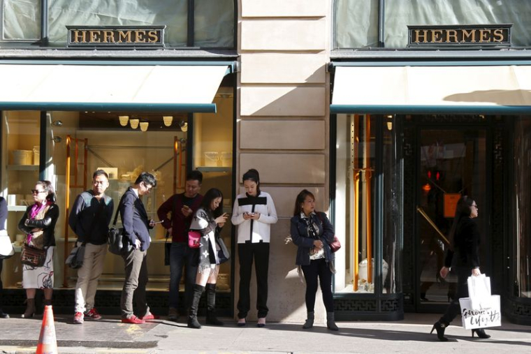 Des clients font la queue en attendant l'ouverture de la boutique principale du groupe de luxe français Hermès à Paris