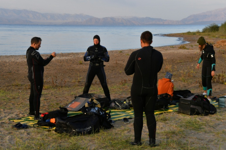 Des plongeurs se préparent à plonger dans les eaux du lac Issyk-Koul, près de  Torou-Aïguyr, au Kirghizstan, le 23 septembre 2026 ( AFP / Vyacheslav OSELEDKO )