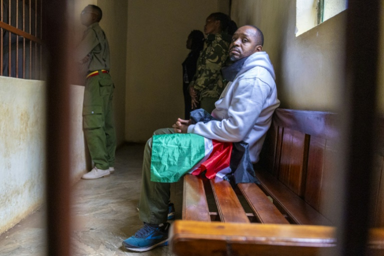 Le militant des droits humains Boniface Mwangi (d) avant sa comparution devant le tribunal de Kahawa, le 21 juillet 2025 à Nairobi, au Kenya ( AFP / SIMON MAINA )