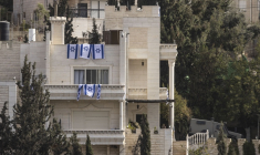 Des drapeaux israéliens sur une maison après que l'armée israélienne a forcé des Palestiniens à évacuer le quartier d'Ein Deir Baha, dans la ville occupée d'Hébron, en Cisjordanie, le 24 octobre 2026 ( AFP / JOHN WESSELS )