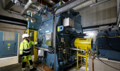 Guy Nicholson, responsable des solutions réseau neutres en carbone chez Statkraft, se tient près d'un volant d'inertie, le 7 août 2025 à Liverpool ( AFP / Darren Staples )