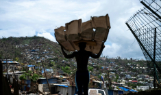 Un homme transporte des matériaux pour reconstruire sa maison à Mamoudzou, à Mayotte, le 2 janvier 2025 ( AFP / JULIEN DE ROSA )