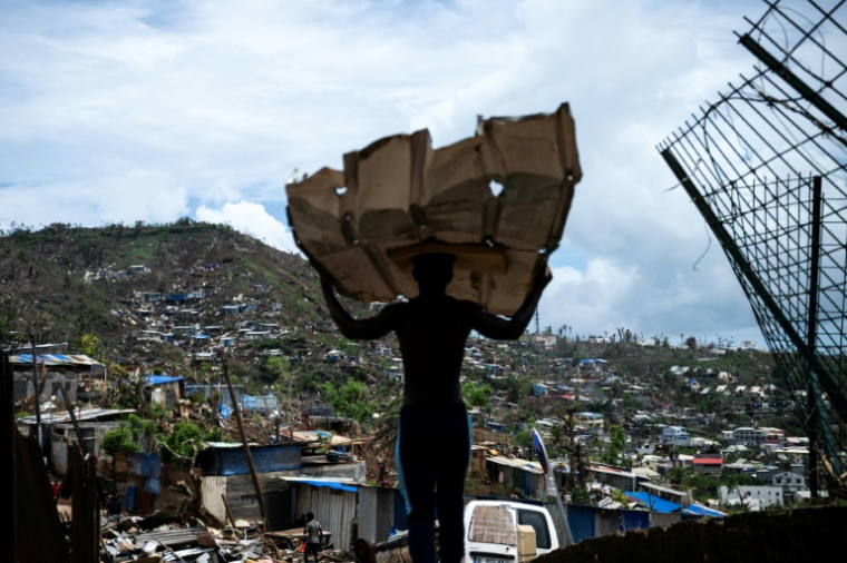 Un homme transporte des matériaux pour reconstruire sa maison à Mamoudzou, à Mayotte, le 2 janvier 2025 ( AFP / JULIEN DE ROSA )