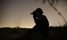 Un agent de la patrouille frontalière utilise des lunettes de vision nocturne pour rechercher les immigrants qui ont franchi illégalement la frontière entre le Mexique et les États-Unis, près de McAllen