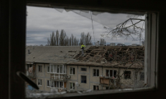 Des ouvriers dégagent les débris du toit d'un immeuble résidentiel fortement endommagé après une frappe de drone russe à Kyiv, le 23 décembre 2025 en Ukraine ( AFP / Roman PILIPEY )