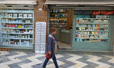 Une Iranienne passe devant une boutique de téléphonie mobile, le 19 avril 2026 à Téhéran ( AFP / ATTA KENARE )