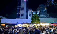 Les employés du centre d'appels surfent sur leurs téléphones portables alors qu'ils se rassemblent devant leur immeuble de bureaux après les secousses du tremblement de terre à Cebu, dans le centre des Philippines, le 30 septembre 2025 ( AFP / Alan TANGCAWAN )