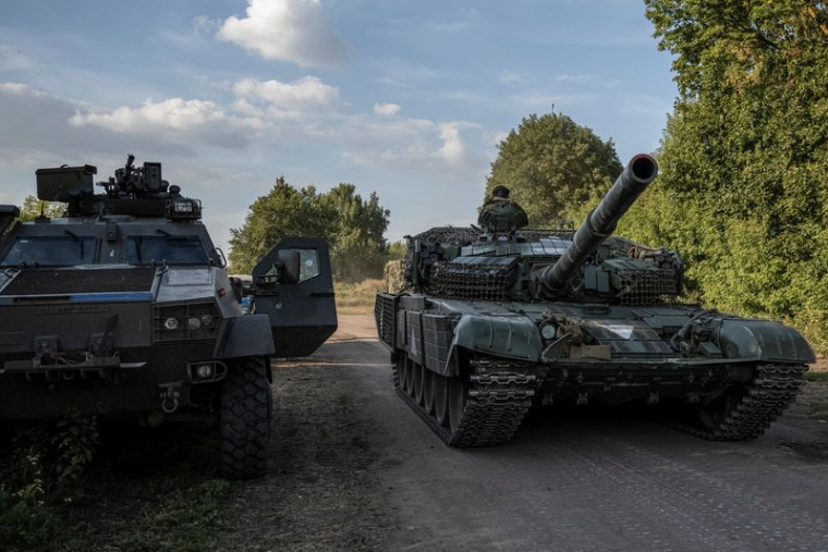 Des militaires ukrainiens montent sur un char près de la frontière russe dans la région de Soumy